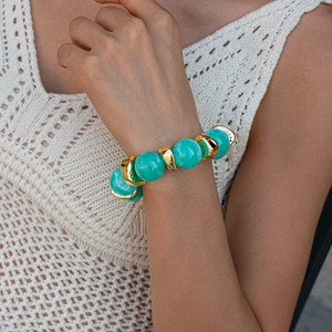 Detail of beaded bracelet with turquoise marble beads and gold crescent metal spacers