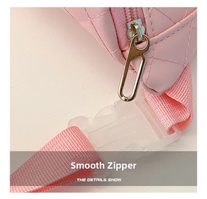 Macro detail of a pink quilted PU chest bag with a smooth silver zipper and woven strap