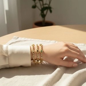 Detailed view of three 18K gold plated evil eye bracelets with zircon on a model wrist