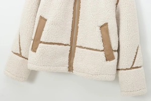 Close-up of contrast fleece jacket with brown trim and metallic zipper detail