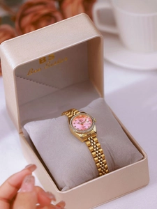 Macro view of gold quartz watch with pink mother of pearl dial in a luxury gift box