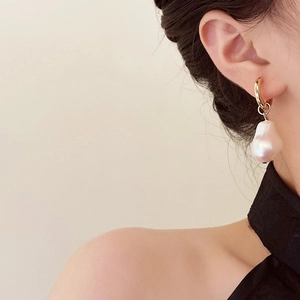 Detailed close-up of French vintage Baroque pearl teardrop earrings with golden hoops