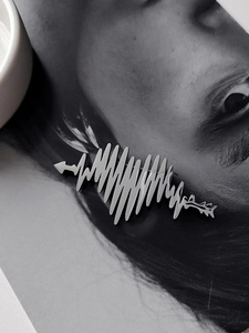 Polished silver heart rhythm brooch pinned on a black and white portrait photo backdrop
