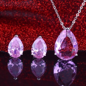 Pink pear-cut gemstone jewelry set including necklace and earrings on red glitter