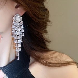 Detail of silver long tassel earrings with sparkling cubic zirconia on a female model