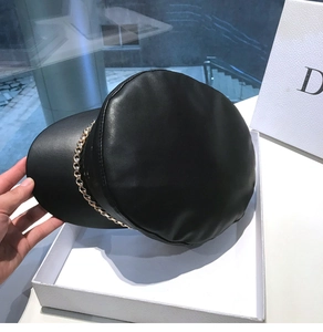 Close-up of black PU leather baker boy hat featuring a decorative gold metal chain strap