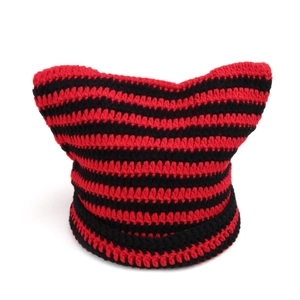 Detail of red and black striped crochet knit cat ear beanie showing textured stitch pattern