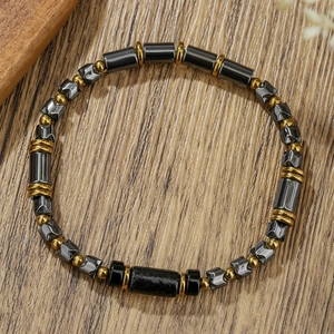 Handmade beaded bracelet with hematite cylinders, black tube beads, and golden spacers