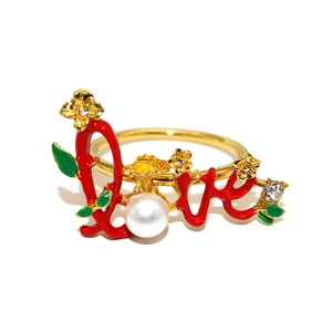 Detailed view of LOVE red enamel napkin ring with gold flowers and pearl inlay