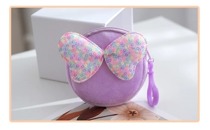 Close-up of lavender purple plush coin purse with a colorful sequin bow and plastic hook