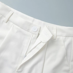 Detail view of the white high-waisted shorts with belt loops and matching button closure