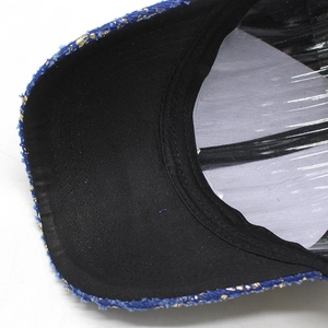 Detailed macro view of denim baseball cap with gold foil pattern and black brim lining