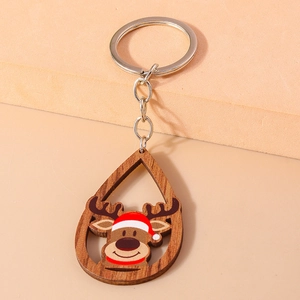 Gros plan d'un porte-clés de Noël en bois en forme de goutte avec renne et anneau argenté