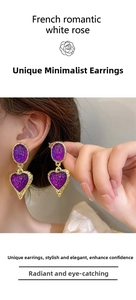 Close-up of vintage heart earrings with purple water ripple texture in gold frame