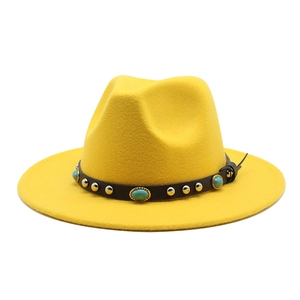 Detail of turquoise stones and metallic rivets on the black leather band of a yellow wool hat