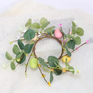 Easter egg wreath with eucalyptus leaves and colorful eggs on white plush background