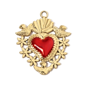 Detailed view of a gold floral engraved bird pendant with a central red heart stone