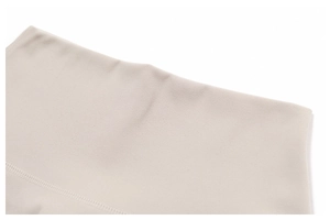 Détail du short de yoga montrant la texture du tissu brossé beige et les coutures fines