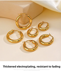 Close-up of three pairs of 18K gold plated stainless steel hoop earrings on a stone base