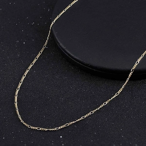 Detailed view of golden Figaro chain necklace on minimalist black display stand