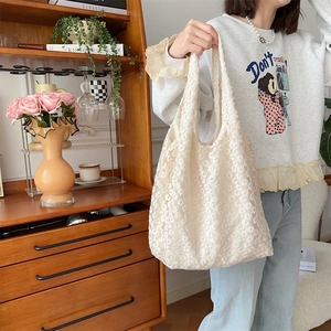 Detail of elegant cream floral lace tote bag with intricate openwork crochet pattern