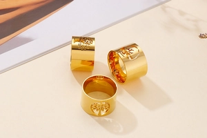 Detailed close-up of golden hollow Tree of Life rings with a polished metal finish