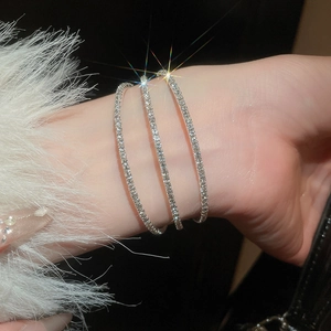 Vue détaillée de bracelets croisés argentés sertis de diamants brillants sur le poignet