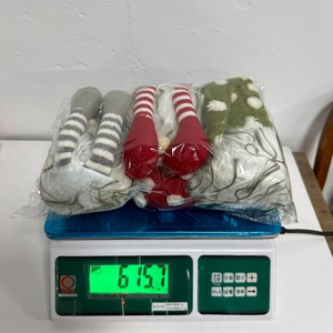 Three-piece set of Christmas gnomes being weighed showing a total weight of 615.7 grams
