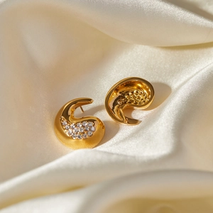 Macro detail of 18k gold plated teardrop earrings with shimmering white zircon stones