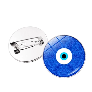 Detailed view showing both sides of a blue evil eye brooch with a secure silver metal pin