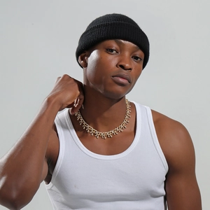 Détail d'un collier hip-hop doré avec design goutte givrée porté par un mannequin