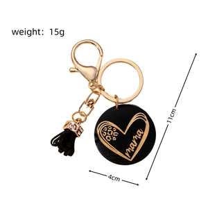 Detail of mama wooden keychain with leopard print heart, tassel and gold ring