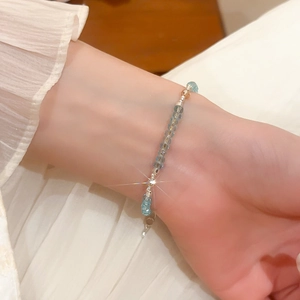 Close-up of light blue geometric crystal beaded bracelet worn on a woman's wrist