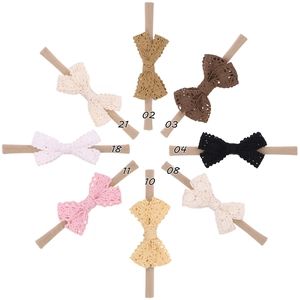 Detail view of 8 assorted lace bow nylon headbands for babies in neutral colors