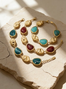 Detailed macro view of 18K gold-plated bracelets with colorful resin insets on stone