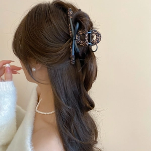 Detail showing high-strength spring and leopard print texture on the hair claw clip