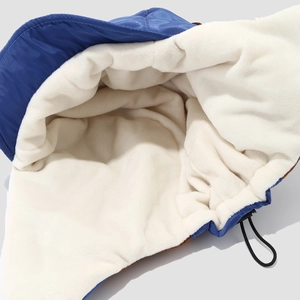 Detail des dicken weißen Plüschfutters und blauen winddichten Stoffes der Fliegermütze