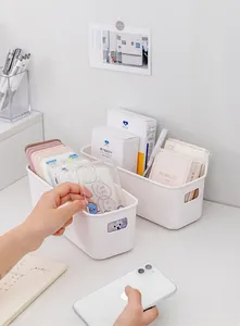White plastic desk storage bin with oval handles for organizing stationery and phone cases