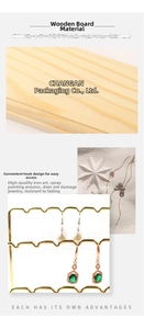 Macro view of gold jewelry organizer featuring wavy metal hooks and 2cm wooden base