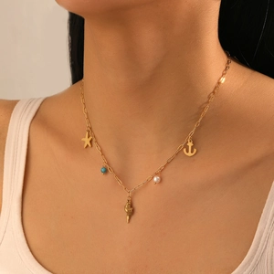 Close-up of golden nautical necklace with starfish and shell pendants on a model's neck