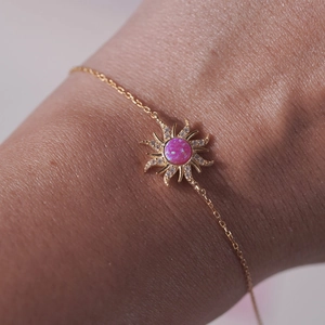 Macro shot of gold sun pendant necklace with pink opal and zircon pavé detail