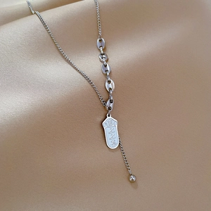 Detailed shot of silver titanium steel chain with engraved lucky charm pendant