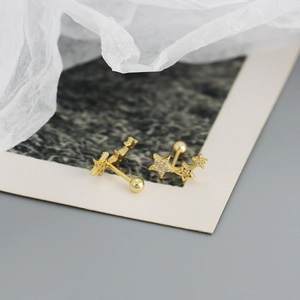 Close-up of gold screw-back earrings featuring three graduated cubic zirconia stars