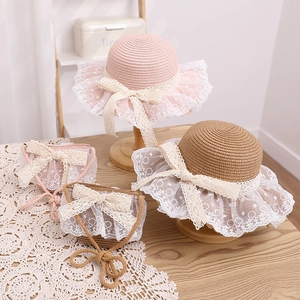 Close-up of children's straw hat and matching lace handbag with sweet bow details