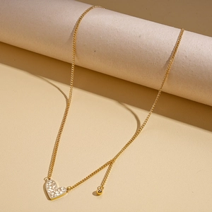 Detailed view of a gold heart pendant necklace with shimmering pave crystals and fine chain