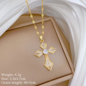 Close-up of gold titanium cross pendant with rhinestones on beige jewelry box