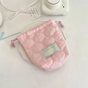 Close-up of pink quilted drawstring storage pouch with cloud texture on ceramic tray