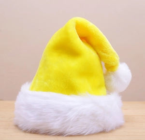 Detail shot of yellow plush Christmas hat with white faux fur texture and pom-pom accent