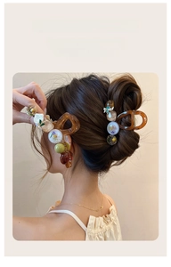 Vue détaillée de dos de pinces à cheveux en ambre avec fleurs séchées sur cheveux longs