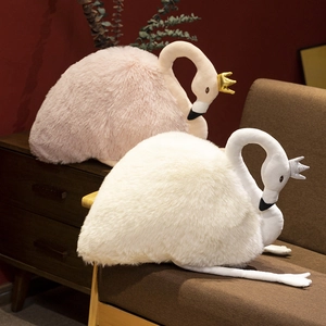 Charming white and pink swan plush toys with golden crowns in a cozy retro room setting